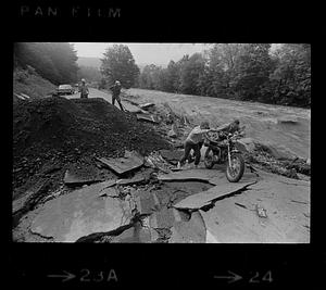 Motorcyclists negotiate washed-out road from Black River flooding, Springfield, Vermont