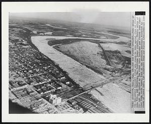Ice Jam Floods Lowlands--Five miles of the ice-gorged Missouri river are shown in this aerial view at Atchison, Kas., and Winthrop, Mo. (extreme lower right). Thirty miles of ice jam has backed up the river into lowlands and forced some families from their homes. Part of the Atchison business district is shown at lower left.