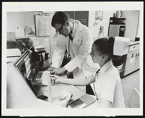 Head Nurse Carolyn Grierson and Dr. Robert Chesne, head of the Good Samaritan Hospital Coronary Care Unit in Los Angeles, discuss a patient's progress in this scene from the 3M Special, "Heart Attack!"