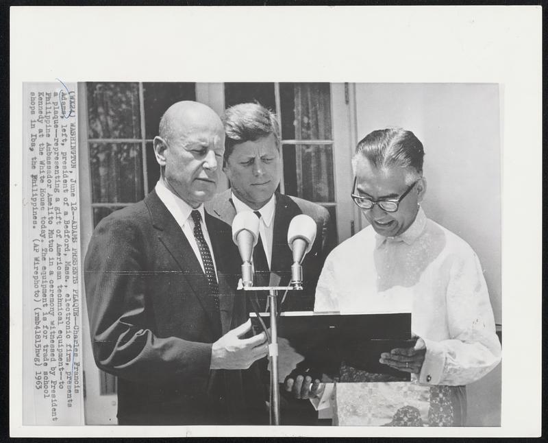 Adams Presents Plaque - Charles Francis Adams, left, president of Bedford, Mass., electronic firm, presents a plaque - representing a gift to American technical equipment - to Philippine Ambassador Amelito Mutuc in a ceremony witnessed by President Kennedy at the White House today. The equipment is for trade school shops in Iba, the Philippines.