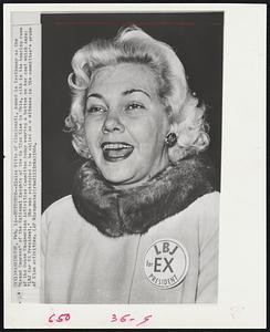 Eloise Witte of Cincinnati, named in testimony as the "Grand Empress" of the National Knights of the Ku Klux Klan in Ohio, sits in the hearing room of the House Un-American Activities Committee today wearing a button on her coat which says: "LBJ for EX President." She was scheduled to be called as a witness in the committee's probe of Klan activities.