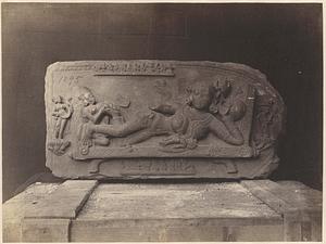Carved panel of female deity, resting on packing crate