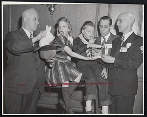 Can You Do It? -- Roger Wheeler of Newtonville, president of Boston chapter of Society of American Magicians, performs an old and easy one at the magician's convention at the Hotel Statler. Watching, left to right, Judith Geissler, 9, of Boston; Dickie Hoehm, 9, of Hanover, N. H.; Gerard M. Friend of Boston and Bert Allerton of Chicago, past national president of the society.