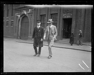 Two men walking in front of jail office