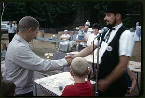 Bicentennial emcee presenting a trophy to a young man at the antique car rally