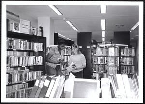 Snapshot of two women in library stacks