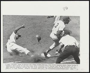 Willie Got There First -- Chicago Cubs first baseman Ernie Banks throws himself feet first at the bag today after fielding fifth inning bunt by Willie Davis (3) of Los Angeles Dodgers. Willie won the race, dropping his batting helmet as he crosses the bag. Umpire is Tony Venzon. Dodgers trounced Cubs 4-1.