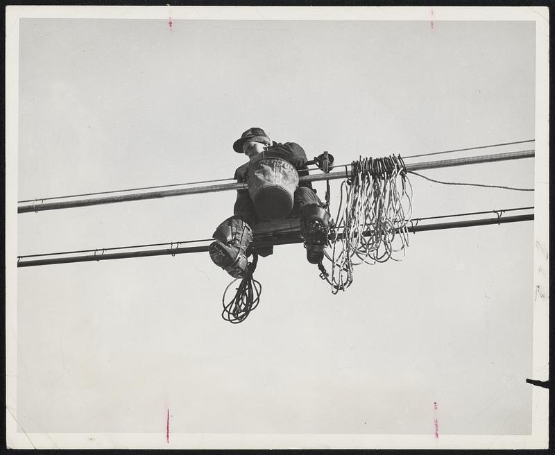 High Wire This lineman perches on one cable as he makes repairs on
