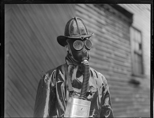Fireman Arthur Thompkinson of Ladder 1, Chelsea, working in gas mask during two alarm rag shop fire