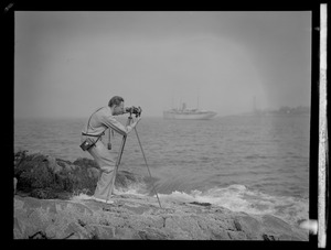 Photographer with tripod by the ocean