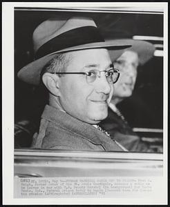 Former Cardinal Owner off to Prison - Fred M. Saigh, former owner of the St. Louis Cardinals, manages a smile as he leaves in car with U.S. Deputy Marshal (in background) for Terre Haute, Ind., federal prison today to begin 15-month term for income tax evasion.