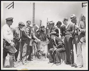 Along the Monroe Steel Front. Armed vigilantes guarding the roads into the city pass the time listening to the radio June 12.