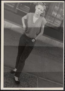 Portrait of a young woman standing on the sidewalk