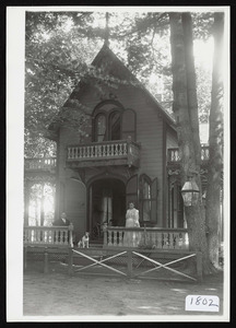 Steep pitched roof, victorian cottage with upper level balconies showing man, woman, and dog on porch, Asbury Grove, So. Hamilton, Mass