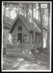 Small steep roof, victorian cottage, named Woodland Rest, with man sitting on porch, Asbury Grove, So. Hamilton, Mass