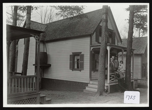 Two men and two women at porch of cottage showing water barrel to collect roof rain, Asbury Grove, So. Hamilton, Mass.