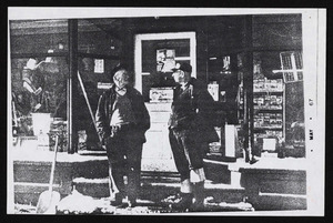Archie McLean, blacksmith, Chuck Haley discuss affairs of importance in front of hardware store, March 1967