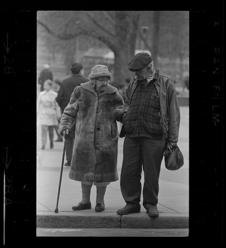 Elderly brother and sister wait to cross Park Street, Boston