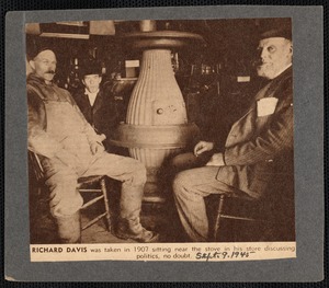 Richard Davis shown sitting by stove in his store with two other men