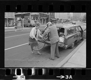 Dr. Paul Dudley White unloading bicycle from station wagon for 5-mile ride from Boston Common to Jamaica Pond