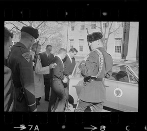 Two handcuffed men being put in car by Massachusetts State Police