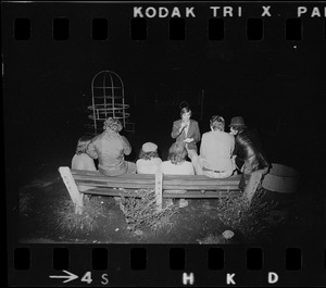 Journalist interviewing group in playground at night