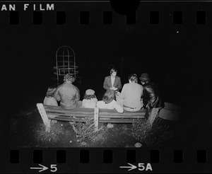 Journalist interviewing group in playground at night