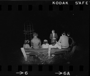 Journalist interviewing group in playground at night