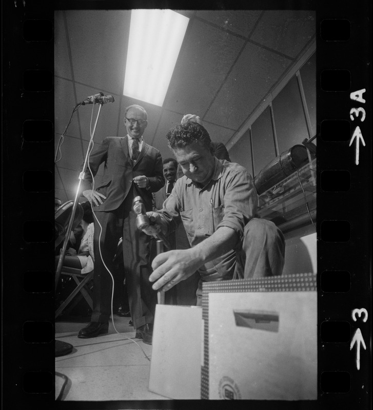 Man opening box of MBTA job applications as MBTA chair Robert C. Wood watches