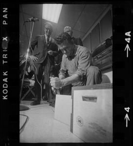 Man opening box of MBTA job applications as MBTA chair Robert C. Wood watches