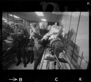 MBTA Manager of Employment John P. Kennedy fills raffle drum with names of job applicants as Joseph C. Kelly and George Coblyn watch