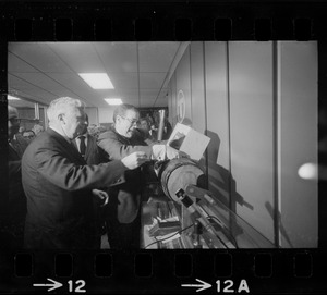 MBTA Manager of Employment John P. Kennedy fills raffle drum with names of job applicants with assistance from William J. Fitzsimmons