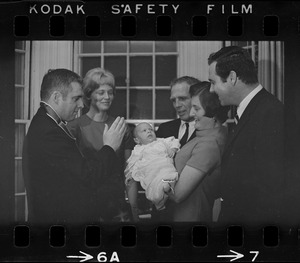 Two-month-old Michael Warner, son of Boston Park Commissioner John Warner (right) is the center of attention as he is baptized by the Rev. Thomas Fleming of St. Patrick's Church, Roxbury. Among those attending the christening, held at Mayor Kevin White's Back Bay home, was the baby's mother, 2nd left, Mayor White, the child's godmother, Mrs. Mary McDonough, wife of city councilor Pat McDonough, and the proud father