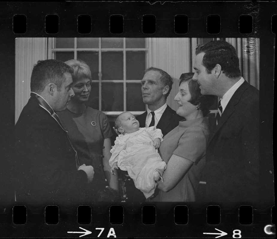 Two-month-old Michael Warner, son of Boston Park Commissioner John Warner (right) is the center of attention as he is baptized by the Rev. Thomas Fleming of St. Patrick's Church, Roxbury. Among those attending the christening, held at Mayor Kevin White's Back Bay home, was the baby's mother, 2nd left, Mayor White, the child's godmother, Mrs. Mary McDonough, wife of city councilor Pat McDonough, and the proud father