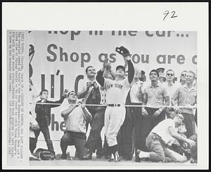 Closeup of Mantle, the Left Fielder - The overflow crowd today's New York Yankees-Cincinnati Reds get a close view of Mickey Mantle as he is about to catch Tommy Harper's fly ball in the third inning. Mantle has been playing in left field, a move by new manager John Keane.