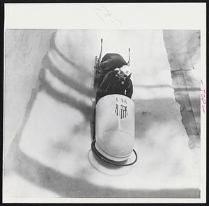 United States Olympic two-man bobsled team takes practice run at Cortina D'Ampezzo, Italy. Bud Washbond, Hartford, steers sled, with Brakeman Pat Biesiadecki of Ware, Mass., crouching behind him.