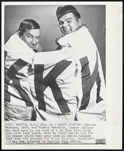 Happy Hunting-Charlie Warriax, left, and Simeon Oxendine, Lumbee Indians who took part in the rout of a Ku Klux Klan rally near here last night, show by their smiles and the KKK banner which they wear like an Indian blanket that they had grounds for happy hunting. Oxendine's cap has the Veterans of Foreign Wars emblem.