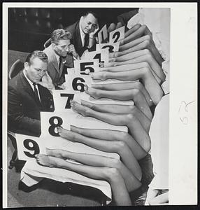 No Hasty Decision was made as these three judges examined nine pairs of legs to decide winner of "Miss Garter Throw" contest at Beverly Hills, Calif. Winner will reign over opening of a Gay 90's saloon. Jim Hayes, Sol Baiano and Jack Freeman, the judges, chose Sandra Joslyn as winner.