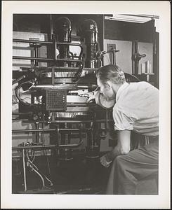Physicist D. L. Mock, above, adjusts the betatron accelerator's 'doughnut' tube