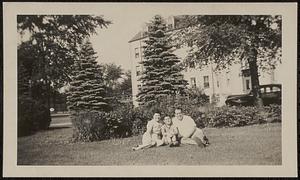 John Pavo with his parents, Yvonne and John, sitting on grounds of the Sacred Heart School
