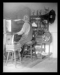 A man playing an instrument while blowing into a horn