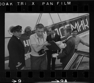 Unidentified men next to Russian oceanographic research ship Akademik Kurchatov, docked at Commonwealth Pier