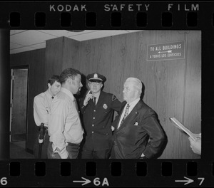 Unidentified men, including police, in hallway