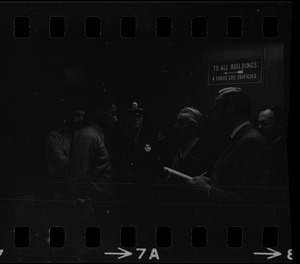 Unidentified men, including police, in hallway