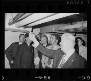 Unidentified men, including police, examining ceiling pipes