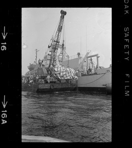 Web of supports holds $1.5 million research submarine Alvin as it is lifted from water at Menemsha Bight before being placed on barge