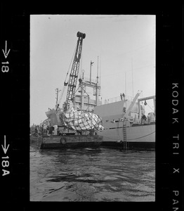 Web of supports holds $1.5 million research submarine Alvin as it is lifted from water at Menemsha Bight before being placed on barge