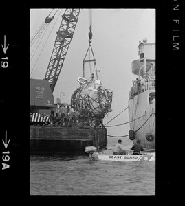 Web of supports holds $1.5 million research submarine Alvin as it is lifted from water at Menemsha Bight before being placed on barge