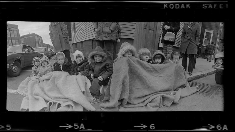 Kids keep warm under a curbside blanket at St. Patrick's Day Parade, Boston