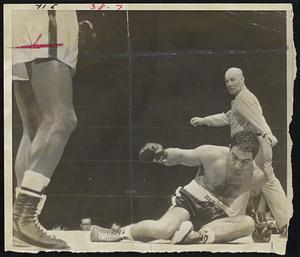 Rocky Marciano Down in first for count of four after Jersey Joe Walcott scored with lead-off flurry. Referee is Charlie Daggert. Rocky climbed off floor to score 13-round knockout and win crown.